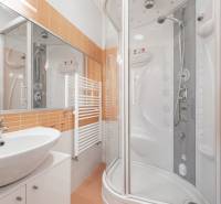 Modern bathroom with a bathtub, sink, and orange tiles in a family house.