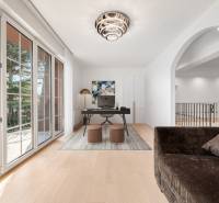 Interior of a family house with a wooden decor floor, large windows, and a work desk.