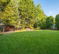 A garden at a family house in Ivanka pri Dunaji with a well-maintained lawn and a wooden house.
