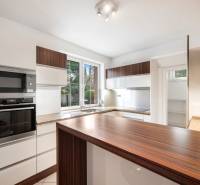 A kitchen with a wood-patterned floor and white cabinets in a family house.