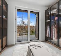 A wardrobe in a family house with sliding closets and a view of the terrace.