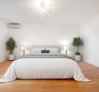 Cozy bedroom with an elegant chandelier and wood-patterned flooring in a family house.