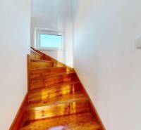 A staircase with a wooden decor leads to the window, Family house.