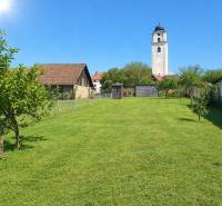 A garden at a family house in Poprad with a view of the tower and blue sky.