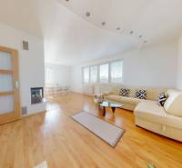 A bright living room in a family house with a fireplace and a wooden decor floor.