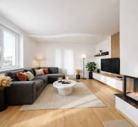 Living room of a family house with a wooden decor floor, a comfortable sofa, and a fireplace.