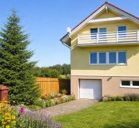 A family house on Poprad Street in Poprad with a landscaped garden and flower beds.