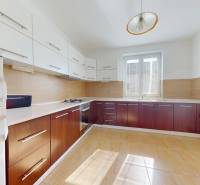 A kitchen with wooden decor, white cabinets, and a large window, family house.