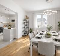 Dining room and kitchen in a family house with a table, white furniture, and a wooden decor floor.