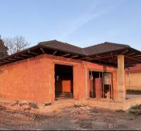 An unfinished family house in Andovce with a brick structure and brown roofing.