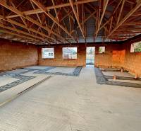 Construction of a family house with brick walls and a wooden roof structure in Andovce.