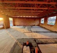 Construction of a family house in Andovce with a concrete floor and brick walls.