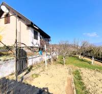 A cottage in Malé Kršteňany with a well-maintained garden and fruit trees.