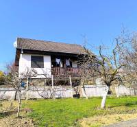 A cottage in Partizánske with fruit trees and a terrace under the blue sky.