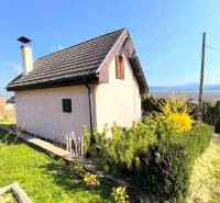 A cottage near Partizánske with a view of the surrounding landscape and a well-maintained garden.