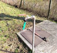 There is an outdoor water faucet by the fence at the exterior of the cottage in Malé Kršteňany.