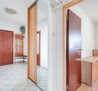 A hallway with a mirrored wardrobe and ceramic tiles in a 3-room apartment.
