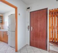 Interior of a 3-room apartment with a kitchen and wooden decor in the hallway.