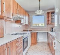 A kitchen in a 3-room apartment with wooden decor and light tiles.