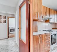 A kitchen with wooden decor and a hallway in a 3-room apartment with a built-in wardrobe.
