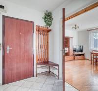 Entrance hall of a 3-room apartment with a coat rack wall, wooden decor, and dining area.