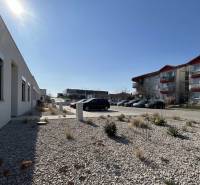 A family house in Klasov with parking, gravel landscaping, and an adjacent apartment building.