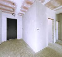 Interior of a family house with a concrete floor and white walls in the finishing stage.