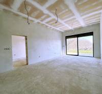 A large room in a family house with a view of the garden through a big window.