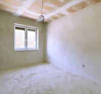 Unfinished room in a family house with a window and white walls.