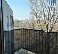 A balcony with a view of trees and buildings, located in a 3-room apartment on Bosákova Street in Bratislava - Petržalka.