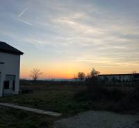 Sunset over residential lands in Neusiedl am See with visible houses.