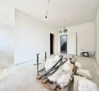 A one-room apartment with white walls and a concrete floor.