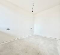 An empty room with white walls and a floor with wood decor in a studio apartment.
