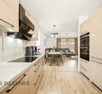 Kitchen and living room in a family house with a wooden decor floor and modern furnishings.