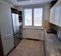 A kitchen in a 2-room apartment with white cabinets and appliances.