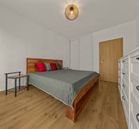 Bedroom in a 2-room apartment, bed, dresser, floor with wooden decor.