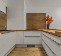 A kitchen in a 2-room apartment with a wooden decor floor and a decorative vase.