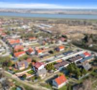 Aerial view of family houses in Vojka nad Dunajom with surrounding landscape and river.