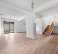 Interior of a family house with a spacious living room, staircase, and wooden decor flooring.