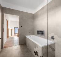 A bathroom with a bathtub and hexagonal tiles in a family house.