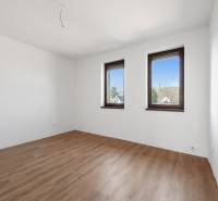 A room with two windows and a floor with a wooden decor in a family house.