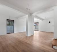 Spacious interior of a family house with a wooden decor floor and a staircase.