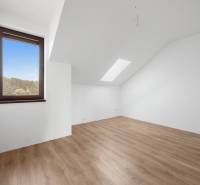 Attic room with a window and wooden decor flooring in a family house.