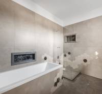 A bathroom in a family house with a bathtub and modern hexagonal tiles.
