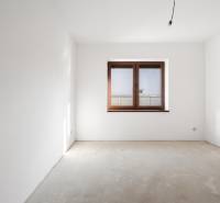 The room in a family house with white walls and a large window.