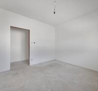 Drywall walls in an unfinished room of a family house with an exposed light bulb.