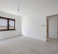 An unfurnished room with a window and a concrete floor in a family house.