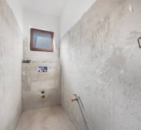 Building a bathroom in a family house with a window and concrete walls.