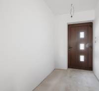 Entrance hall in a family house with white walls and wooden doors.