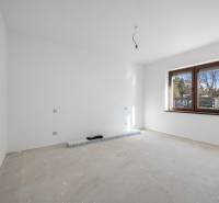 Empty room with white walls and a large window in a family house.